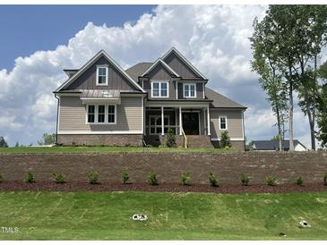 Beautiful two-story home with gray and brown siding, brick foundation, and manicured lawn at 165 Cotton Fields Ln # 25, Fuquay Varina, NC 27526