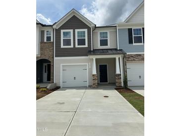 Charming multi-tone townhome featuring a one-car garage, neutral siding, and stone accents at 605 Leland Hl Cir, Zebulon, NC 27597