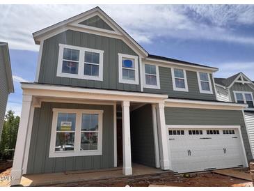 Charming two-story home with board and batten siding, white trim, and a two-car garage at 63 Daybreak Way, Fuquay Varina, NC 27526