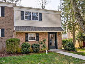Charming two-story home with brick and siding, complemented by dark shutters and lush landscaping at 6525 New Market Way, Raleigh, NC 27615