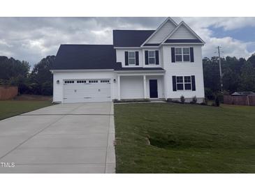 Charming two-story home featuring a two-car garage, dark shutters, and a well-manicured lawn at 81 Reece Dr, Sanford, NC 27332