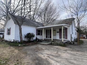 Charming white cottage-style home with a covered porch and maroon shutters at 901 W Anderson St, Selma, NC 27576