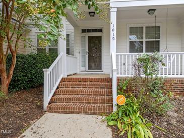 Charming front porch with brick steps, white railings, and inviting entrance at 1012 Palace Garden Way, Raleigh, NC 27603