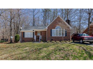 Charming brick home features a manicured lawn and a neatly paved driveway with a red SUV at 1253 Skyview Dr, Mebane, NC 27302