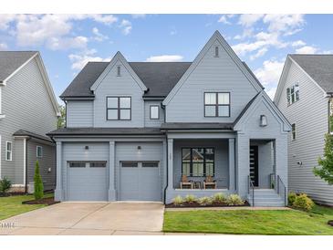 Charming two-story home featuring a covered front porch, grey siding, and a two-car garage at 183 Post Oak Rd, Chapel Hill, NC 27516