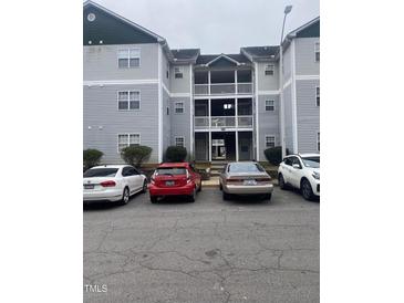 Exterior shot of apartment building with multiple levels and parking area, offering convenience and community living at 2002 Technology Woods Drive # 103, Raleigh, NC 27603