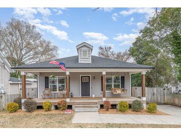 Charming home with a cozy front porch, rocking chairs, swing, and manicured landscaping at 202 W Hill St, Benson, NC 27504