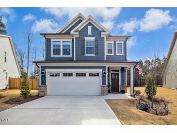 Charming two-story home with a two-car garage, blue siding, and manicured front yard at 2515 Maplemere Ct, Durham, NC 27703