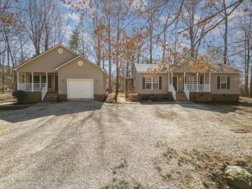 Charming homes with a large gravel driveway and well-maintained lawns offer a welcoming curb appeal at 3011 Little Creek Ln, Hillsborough, NC 27278