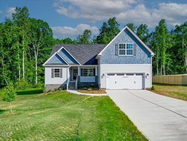 Charming home with a two-car garage, light blue shingle accents, and a well-manicured lawn at 5389 Salem Woods Dr # 12, Graham, NC 27253