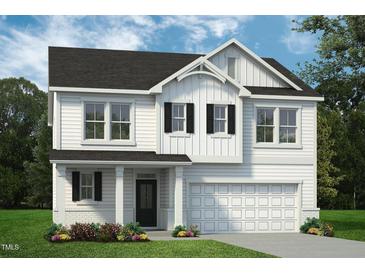 Charming two-story home featuring a light exterior, a welcoming entryway, and an attached two car garage at 73 Merle Dr, Wendell, NC 27591