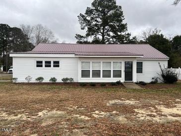 Charming single-story home featuring a metal roof, light-colored siding and a well-maintained lawn at 102 Sue Ave, Dunn, NC 28334