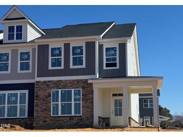 New construction home with stone accents and covered front porch offers a modern appeal at 1581 Wendell Valley Blvd, Wendell, NC 27591