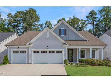 Charming home with a two-car garage, well-manicured lawn and mature trees, offering curb appeal at 163 English Violet Lane Ln, Raleigh, NC 27610