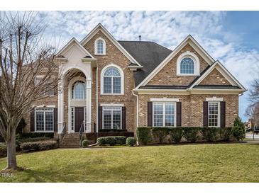 Stately brick home with arched windows and grand entrance, set on a well-manicured lawn at 2000 Falls Farm Crossing Xing, Raleigh, NC 27614