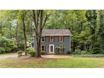 Charming two-story home with red shutters and inviting front yard surrounded by mature trees at 2301 Pastille Ln, Raleigh, NC 27612