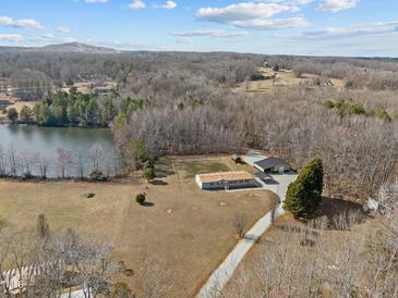 Sprawling property featuring a charming home, large shop, shed, and waterfront access on a tranquil lake at 341 Acorn Ct, Rougemont, NC 27572