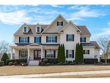 Stunning two-story home with beautiful landscaping, black shutters and a covered front porch at 5025 Fanyon Way, Raleigh, NC 27612
