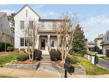 Charming white brick home featuring a welcoming front porch and beautifully landscaped front yard at 543 Guilford Cir, Raleigh, NC 27608