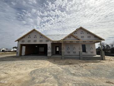 An incomplete charming one-story home featuring a two-car garage under a cloudy sky at 56 Bailey-Boykin Rd, Selma, NC 27576