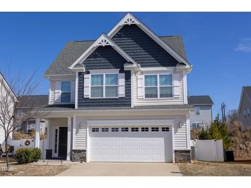 Charming two-story home with a white garage door, gray siding, and well-manicured lawn on a sunny day at 141 W Falcon Ct., Clayton, NC 27520