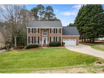 Charming two-story brick home with manicured lawn and attached two-car garage at 1716 Turtle Ridge Way, Raleigh, NC 27614