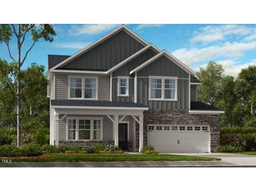 Charming two-story home with stone accents, a two-car garage, and a beautifully landscaped front yard at 201 Hiddenite Pl, Holly Springs, NC 27540