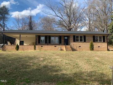 Charming brick home with covered front porch, black shutters, and a well-manicured front lawn at 209 Reade Dr, Roxboro, NC 27573