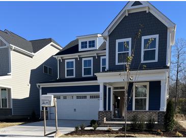 Charming two-story home with a blue exterior, brick foundation, well-manicured lawn, and a two-car garage at 320 Catheys Crk Cir, Wendell, NC 27591