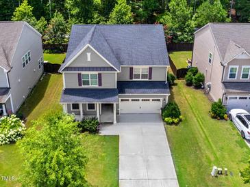 Charming two-story home with a well-manicured lawn and a spacious two-car garage at 428 Morgan Ridge Rd, Holly Springs, NC 27540