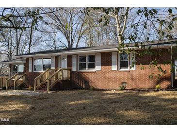 Charming brick home featuring a front porch and white shutters at 5845 Farmwell Road Rd, Raleigh, NC 27610