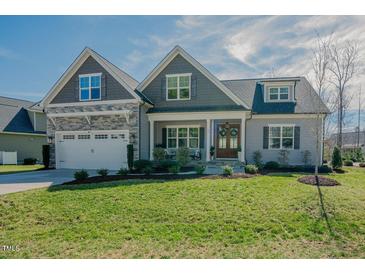 Charming two-story home with well-manicured lawn and attached two-car garage at 65 Walking Trl, Youngsville, NC 27596