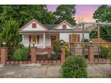Charming front exterior of a two-story home with a landscaped yard, black fence, and a welcoming porch at 905 N Hyde Park Ave, Durham, NC 27701