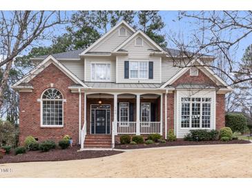 Charming two-story brick home with a covered front porch and manicured landscaping at 100 Tavernelle Pl, Cary, NC 27519