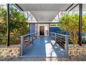 Inviting entrance featuring a covered walkway, colorful landscaping, and modern railings leading to the front door at 1004 Kings Mill Rd, Chapel Hill, NC 27517