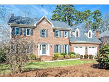 Charming brick home with manicured lawn, two-car garage and inviting entryway at 104 Buckden Pl, Cary, NC 27518