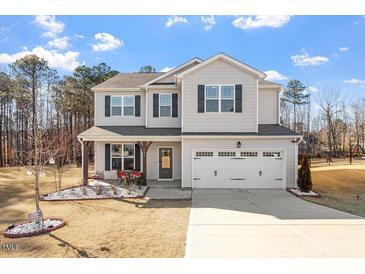 Charming two-story home with gray siding, black shutters, and a welcoming front porch at 106 Capanne Ct, Clayton, NC 27527