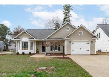 Charming one-story home featuring a well-maintained front yard and a convenient attached garage at 11228 N Radner Way, Raleigh, NC 27613