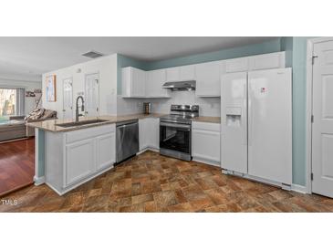 Well-lit kitchen with white cabinets, stainless steel appliances, and granite countertops at 209 Intern Way, Durham, NC 27713