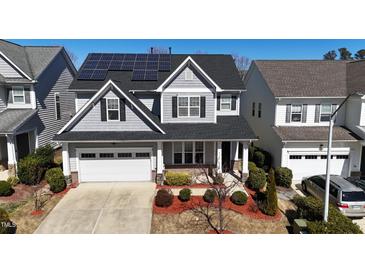 Charming two-story home with a well-manicured lawn, solar panels, and an attached garage at 2132 Royal Berry Ct, Cary, NC 27511