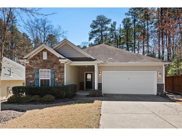 Charming home featuring a stone facade, attached two-car garage, and well-manicured front yard at 23 Juliette Dr, Durham, NC 27713