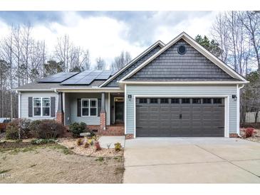 Charming single-Gathering home featuring a two-car garage, solar panels, and professionally landscaped yard at 290 Silver Creek Dr, Clayton, NC 27520