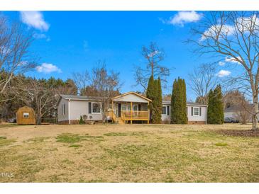 Charming single-story home features a covered front porch and well-maintained yard with mature trees at 5636 Thom Rd, Mebane, NC 27302