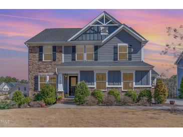Charming two-story home with stone and siding, complemented by lush landscaping at 710 Legacy Falls S S Dr, Chapel Hill, NC 27517