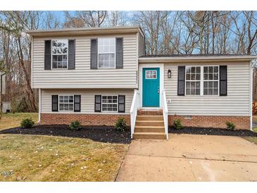 Charming split-level home with a bright blue front door and well-maintained landscaping at 8341 Wynewood Ct, Raleigh, NC 27616
