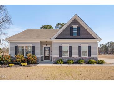 Charming single-story home with gray siding, stone accents, and a well-manicured front yard at 84 Nonabell Ln, Four Oaks, NC 27524