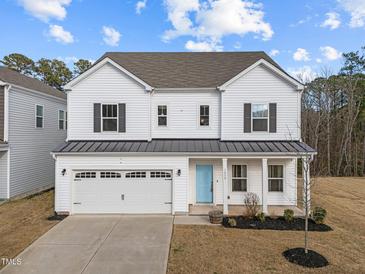 Charming two-story home with a two-car garage, light blue front door and well-manicured front lawn at 1026 Janiskee Rd, Durham, NC 27703