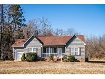 Charming single Gathering home with an attached garage, manicured lawn and well-maintained landscaping at 159 Valhalla Dr, Timberlake, NC 27583