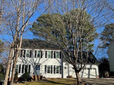 Traditional two-story home boasting white siding, black shutters, attached two-car garage, and landscaped front yard at 2006 Chedington Dr, Apex, NC 27502