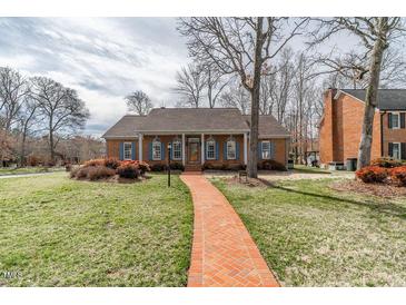 Charming single-story brick home with a well-manicured lawn and a red brick walkway at 2504 Churchill Dr, Burlington, NC 27215